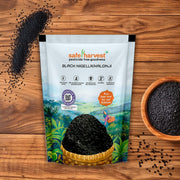 Safe Harvest pesticide-free kalonji black nigella seeds pack with seeds in a brown bowl on a wooden surface.
